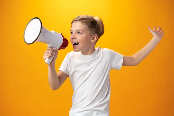 Little boy with megaphone on yellow background — 스톡 사진