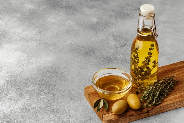 Оливки та пляшка оливкової олії на дерев'яному фоні — стокове фото
