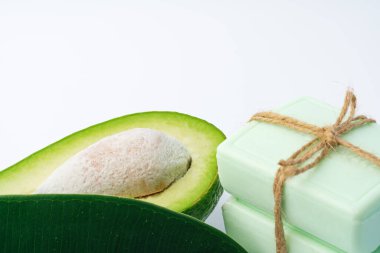 Beyaz arkaplanda avokado olan sabun çubuğu