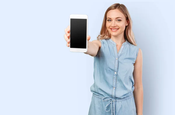 Portrait of a smiling woman showing blank smartphone screen isolated on a color background — Stock Photo, Image