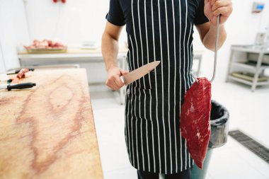 Kesip satmak için elinde et tutan kasap.