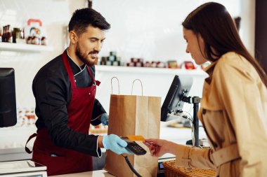 Markette kredi kartı ödeyen genç bir kadın..