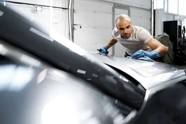 Africano americano homem serviço de carro trabalhador aplicando revestimento nano em um carro — Fotografia de Stock