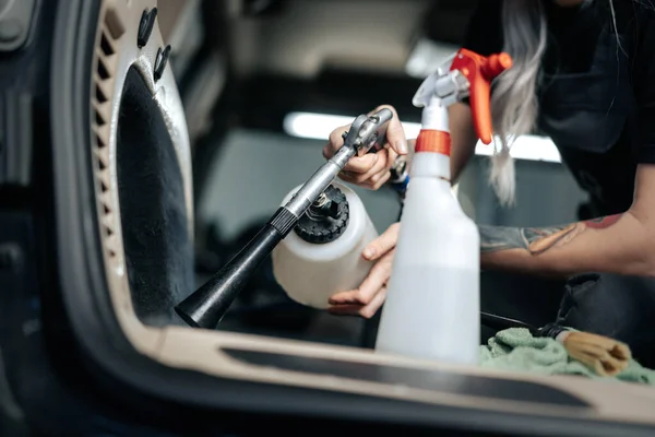 Donna pulizia salone auto con spray lucidante in auto servizio di dettaglio — Foto Stock