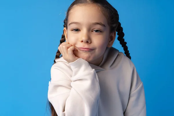 Little girl thinking and looking up over blue background — Stock Photo, Image