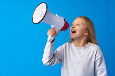 Mavi arka planda megafon kullanan kız çocuğu