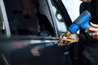 Bir arabaya nano kaplama uygulayan erkek araba servisini kapatın.