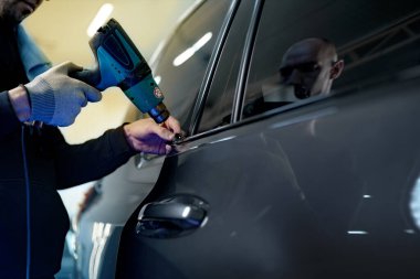 Bir arabaya nano kaplama uygulayan erkek araba servisini kapatın.