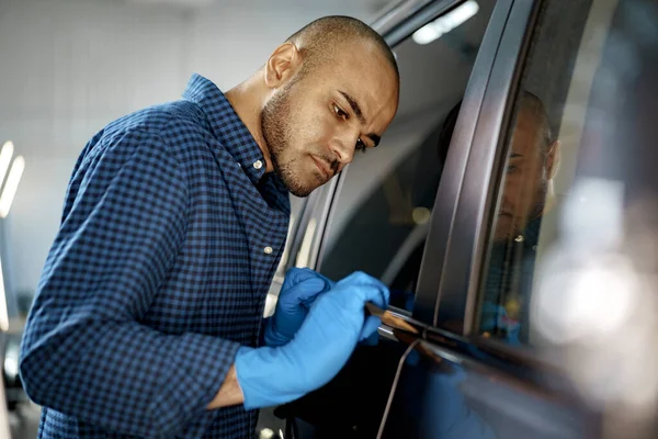 Αφροαμερικάνος εργάτης αυτοκινήτων που εφαρμόζει νανοεπίστρωση σε αυτοκίνητο — Φωτογραφία Αρχείου