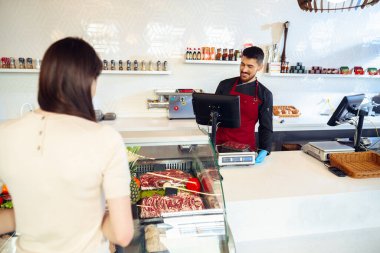 Gıda mağazasında çiğ et reyonuna karşı kadın müşteri