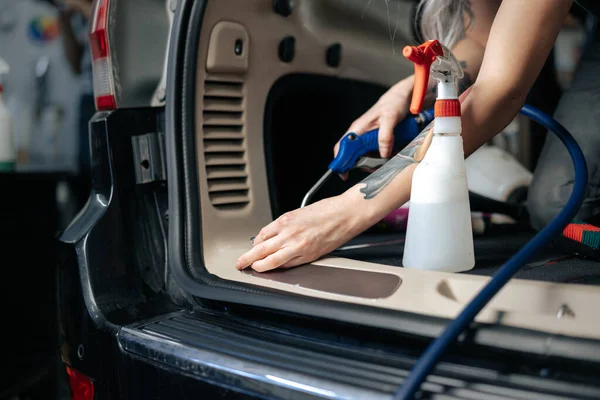 Γυναικείο σαλόνι αυτοκινήτου καθαρισμού με σπρέι στίλβωσης σε αυτοκίνητο λεπτομερώς υπηρεσία — Φωτογραφία Αρχείου