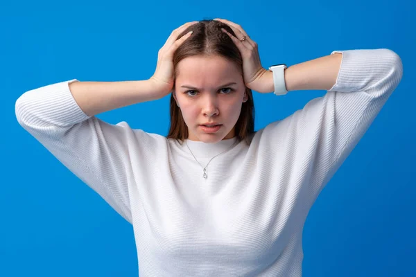 Young woman with headache against blue background — Stock Photo, Image