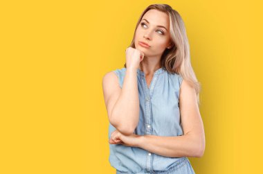 Güzel, genç ve düşünceli bir kadın. Renkli arka planda yalnız poz veriyor..