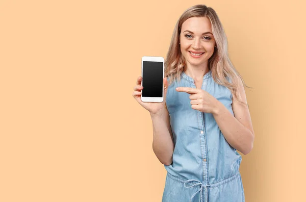 Portrait of a smiling woman showing blank smartphone screen isolated on a color background — Stock Photo, Image