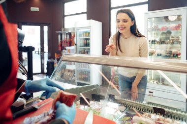 Gıda mağazasında çiğ et reyonuna karşı kadın müşteri