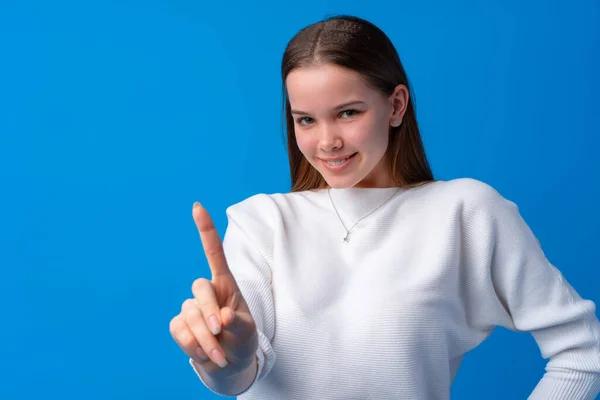 Allegro adolescente che punta il dito contro la fotocamera su sfondo blu — Foto Stock