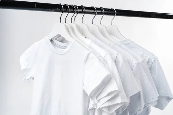 Clothes hang on clothing rack over white background. — Stock Photo, Image