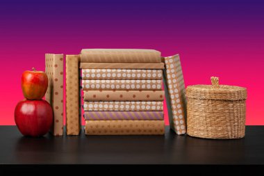 Siyah ahşap masada yığınla kitap.