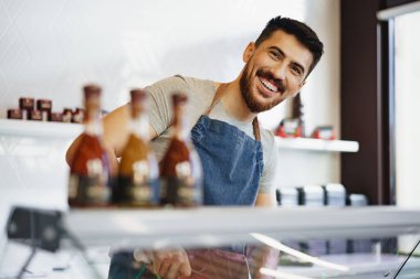 Kasapta duran kendinden emin genç bir satıcının portresi.