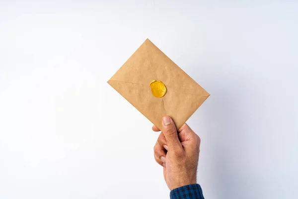 하얀 표면 위로 닫혀 있는 봉투를 들고 있는 남자 손 — 스톡 사진