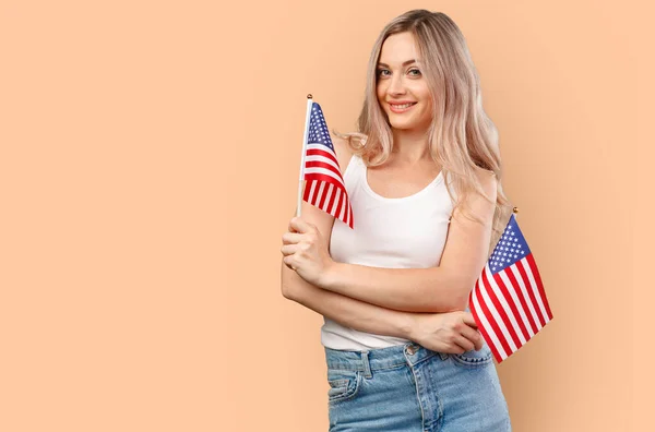 Retrato de uma jovem segurando bandeira dos EUA isolada no fundo da cor — Fotografia de Stock