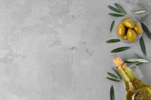 Плоска композиція з оливок та оливкової олії на сірому фоні — стокове фото