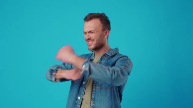 Mavi arka planda başarıyı kutlayan genç adam