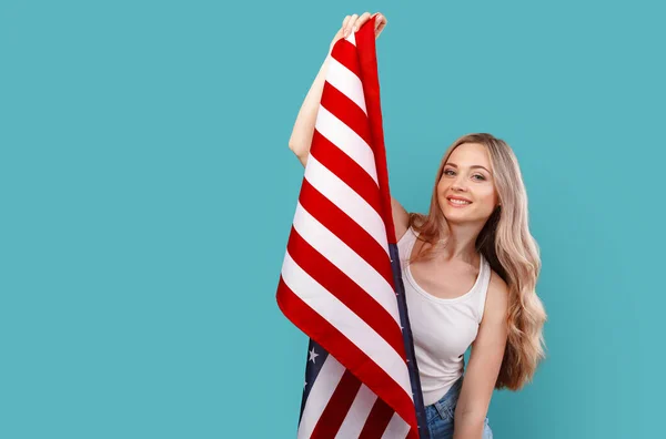 Retrato de uma jovem segurando bandeira dos EUA isolada no fundo da cor — Fotografia de Stock