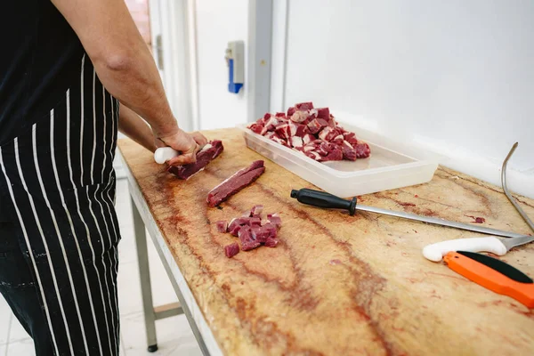 Metzger schneidet rohe Fleischscheiben auf Holzbrett — Stockfoto