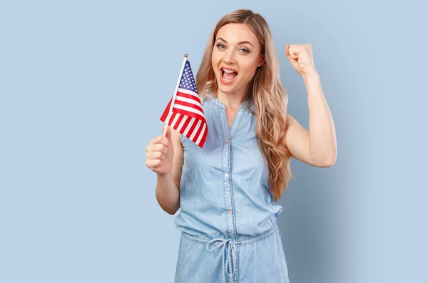 Πορτρέτο μιας νεαρής χαμογελαστής γυναίκας που κρατά τη σημαία των ΗΠΑ απομονωμένη σε φόντο χρώματος — Φωτογραφία Αρχείου