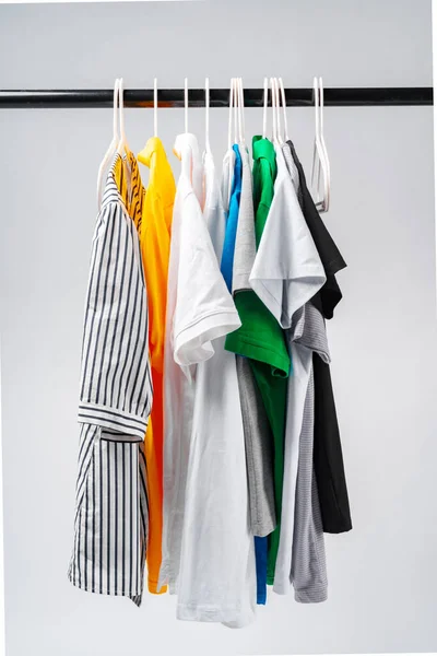 Roupas pendurar no rack de roupas sobre fundo branco. — Fotografia de Stock