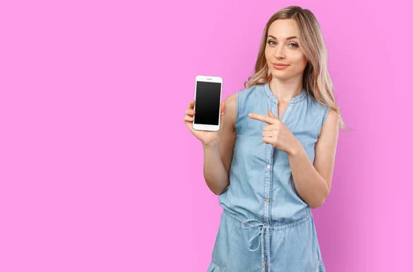 Portrait d'une femme souriante montrant un écran de smartphone vide isolé sur un fond de couleur — Photo