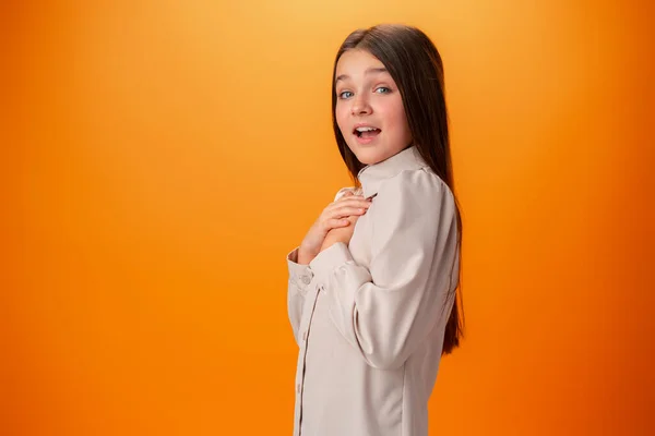 Scioccato gioioso teen ragazza contro arancio sfondo — Foto Stock