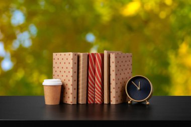 Bulanık arka plana karşı ahşap masadaki kitap yığını