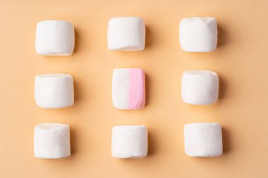 Bej stüdyo arka planında pofuduk marşmelovlar, üst manzara.