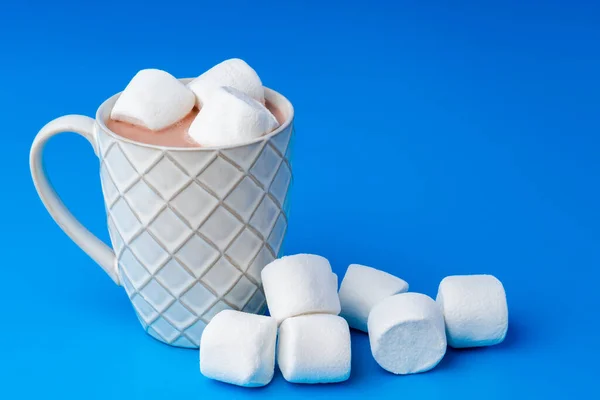 Cup of hot cocoa drink with marshmallows on blue background — Stock Photo, Image