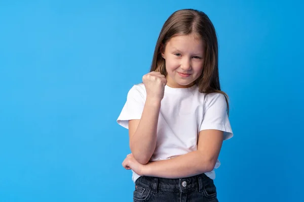 Menina bonito mostrando sua força no fundo azul — Fotografia de Stock