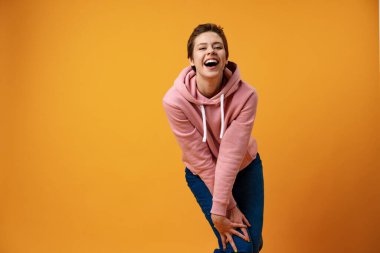 Kısa saçlı, gülümseyen bir kadının stüdyo portresi.