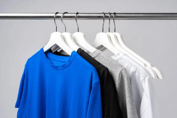 Clothes hang on clothing rack over white background. — Stock Photo, Image