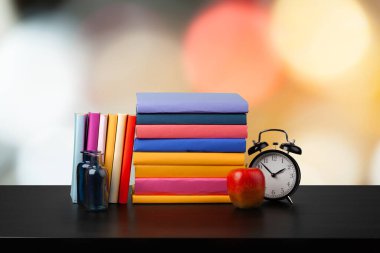 Bulanık arka plana karşı ahşap masadaki kitap yığını