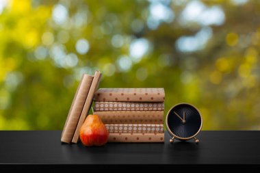 Bulanık arka plana karşı ahşap masadaki kitap yığını