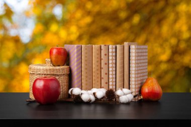 Bulanık arka plana karşı ahşap masadaki kitap yığını