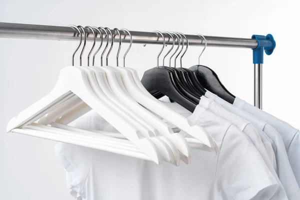 Ρούχα κρέμονται σε σχάρα ρούχα πάνω από λευκό φόντο. — Φωτογραφία Αρχείου