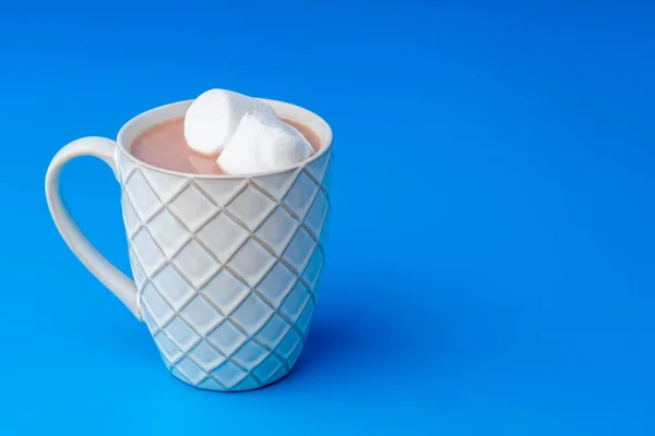 Cup of hot cocoa drink with marshmallows on blue background — Stock Photo, Image