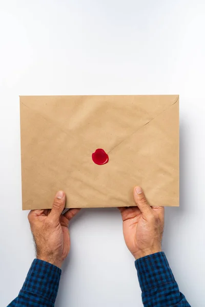 Mains masculines tenant une enveloppe avec un sceau de cire — Photo