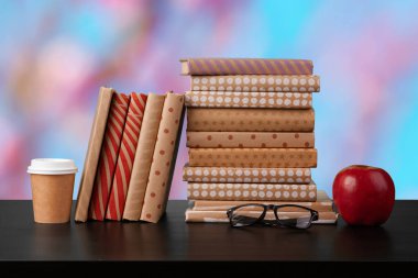 Bulanık arka plana karşı ahşap masadaki kitap yığını