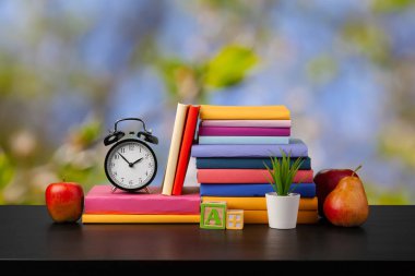 Bulanık arka plana karşı ahşap masadaki kitap yığını