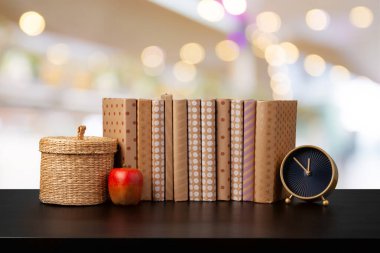 Bulanık arka plana karşı ahşap masadaki kitap yığını