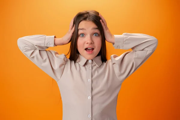 Chocado alegre teen menina contra laranja fundo — Fotografia de Stock