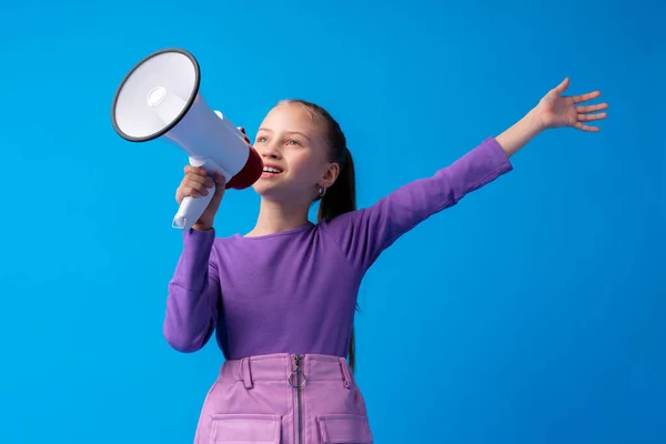 Menina criança usando megafone contra fundo azul — Fotografia de Stock